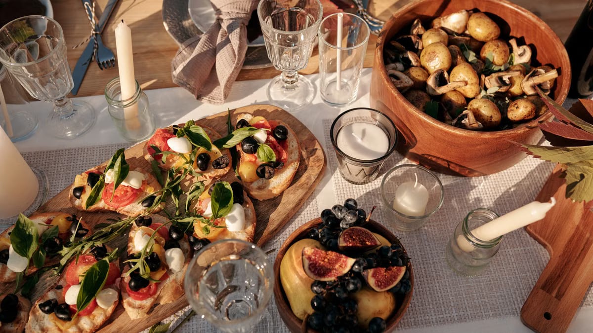 A beautifully set outdoor dining table featuring an array of fresh vegan dishes under sunlight.
